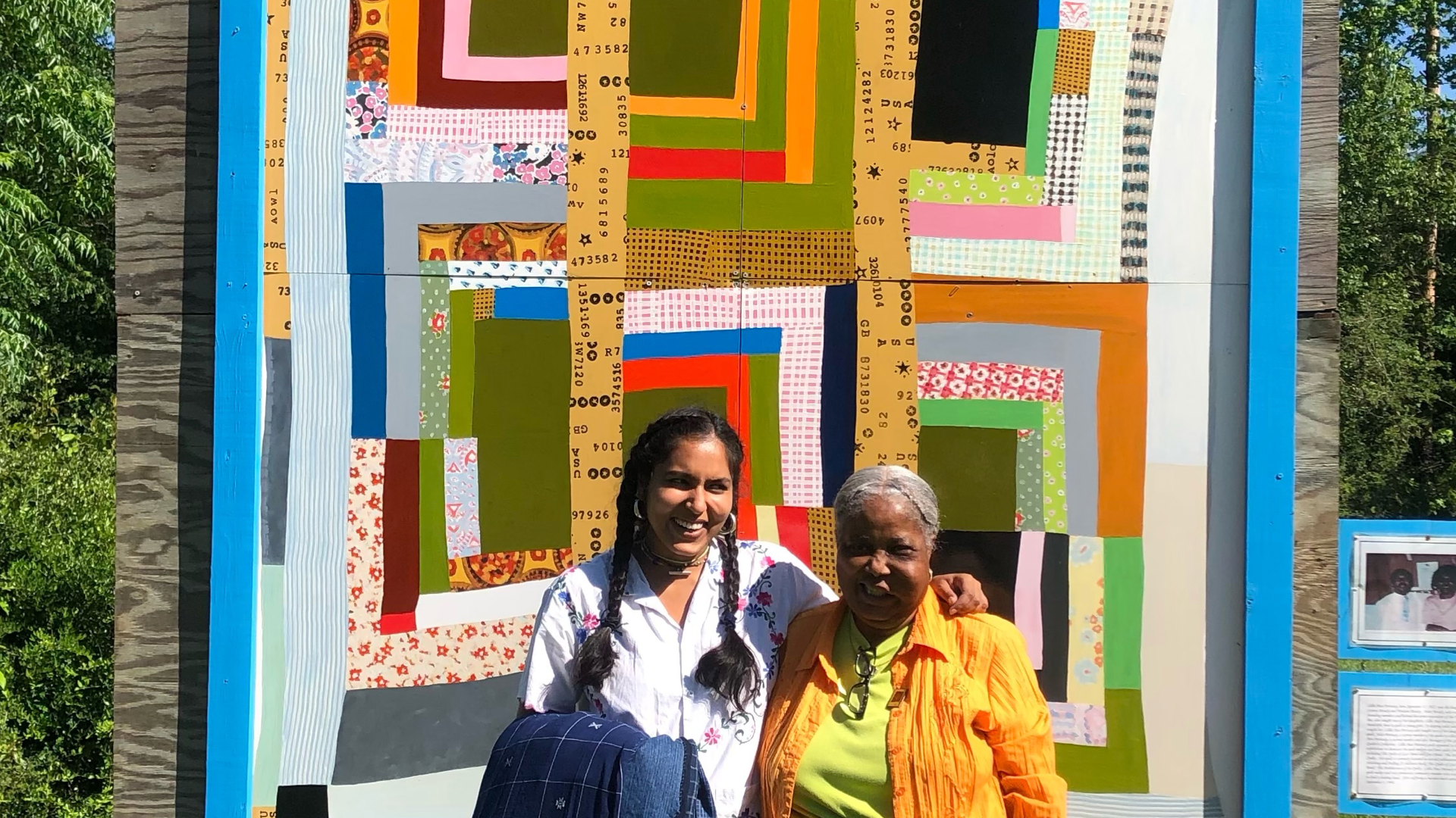 Bhasha Chakrabarti and Mary Ann Pettway in front of a reproduction of Lillie Mae Pettway's Housetop twelve-block "Half-Log Cabin" variation, c.1965, Museum of Fine Arts, Boston 